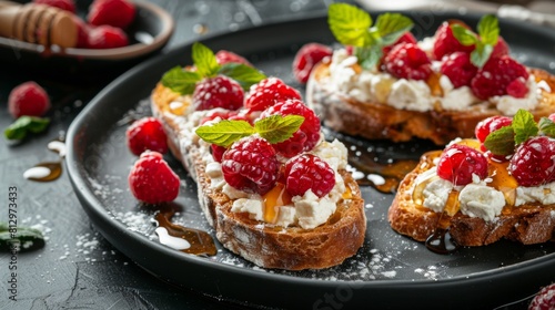 Crostini with raspberries and goat cheese  sprinkled with fresh raspberries. Sprinkled with honey and decorated with fresh mint leaves.