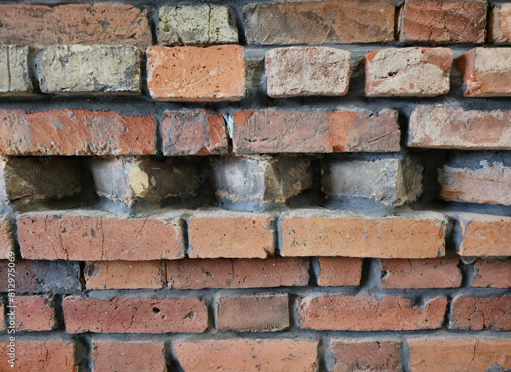 Obraz premium Ceglana , murowana pomarańczowa ściana z detalami ceglanymi budynku loftowego, industrialna architektura