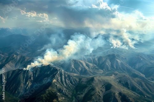 Smoke billowing up over a mountain range, visible signs of a distant wildfire impacting the landscape  © fotogurmespb