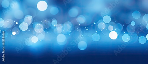 A blue background with out of focus highlights known as bokeh creates an appealing copy space image