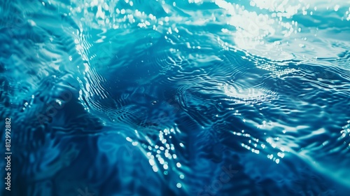 Bright sunlit blue water surface close-up in deep sea.