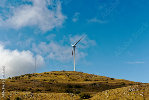 Mountain panorama with turbines of a wind farm producing clean and sustainable electricity helping the environment and the earth.  Green ecological power energy generation. Wind farm eco field photo