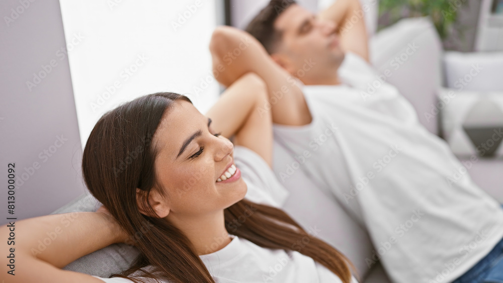 A peaceful couple relaxes together indoors, exuding love and contentment in a cozy living room. A peaceful couple relaxes together indoors, exuding love and contentment in a cozy living room.