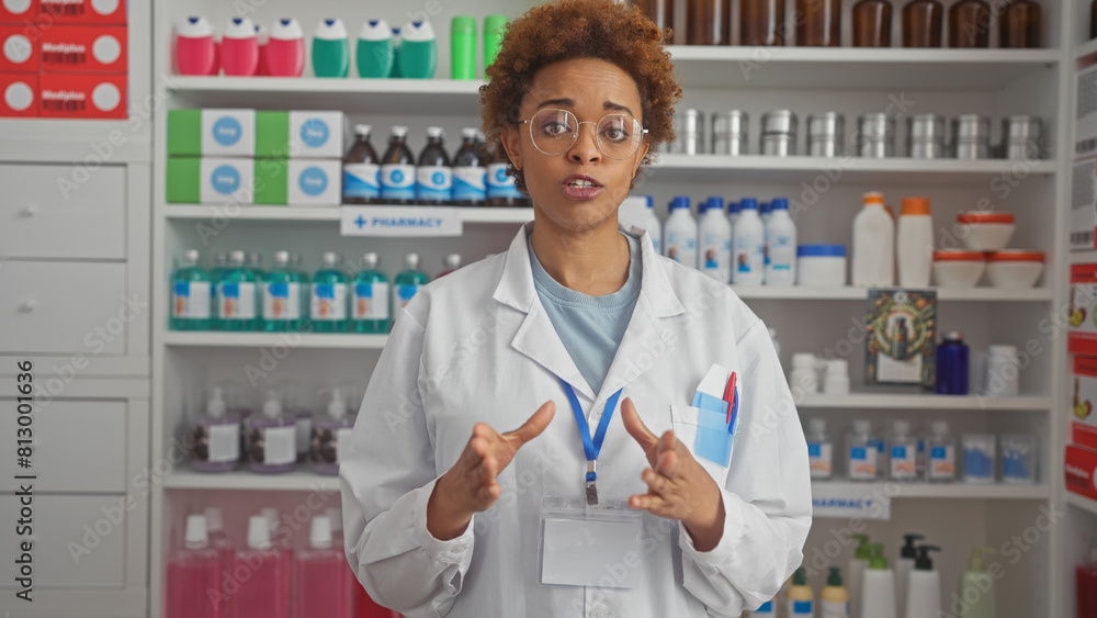 African american woman pharmacist in white coat talking in a pharmacy.