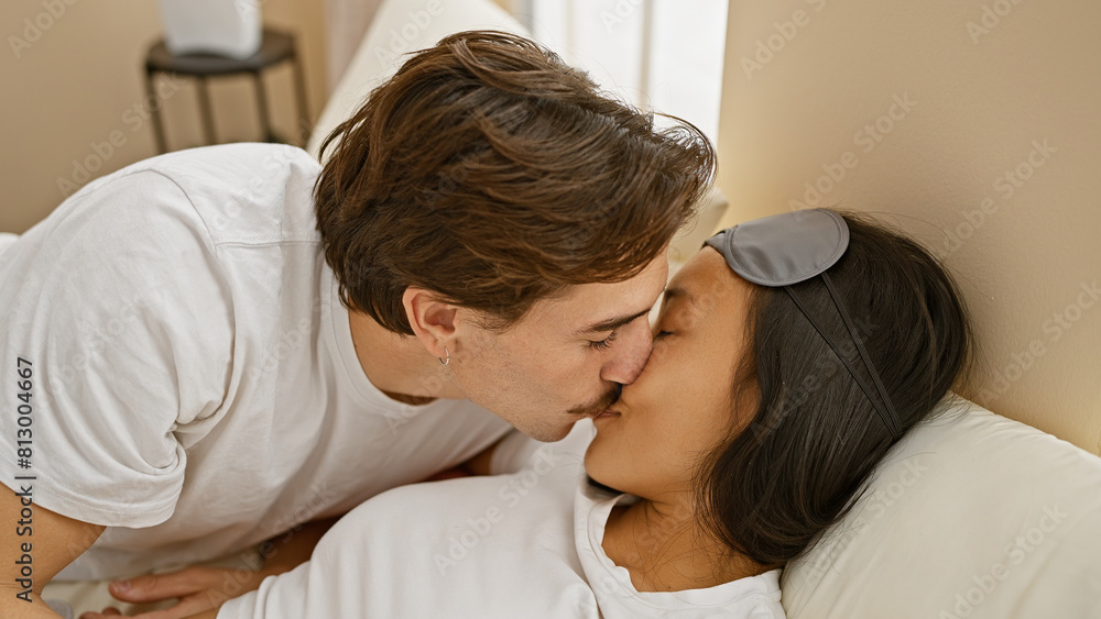 Intimate interracial couple kissing gently in a cozy bedroom setting, evoking love and closeness. Intimate interracial couple kissing gently in a cozy bedroom setting, evoking love and closeness.