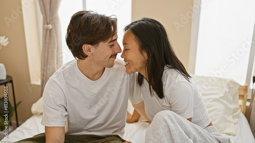 Interracial couple embracing in a cozy bedroom, evoking love, togetherness, and diversity.