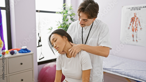 A male therapist performs a neck adjustment on a female patient in a brightly lit physical therapy clinic photo