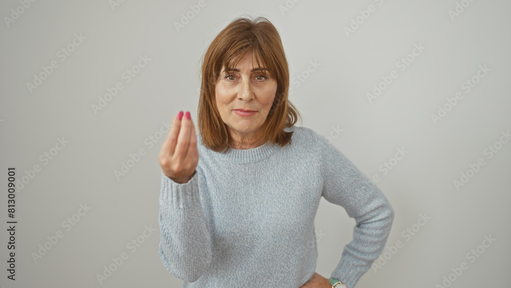 A poised mature woman with short hair confidently extends her hand against a white background. A poised mature woman with short hair confidently extends her hand against a white background.