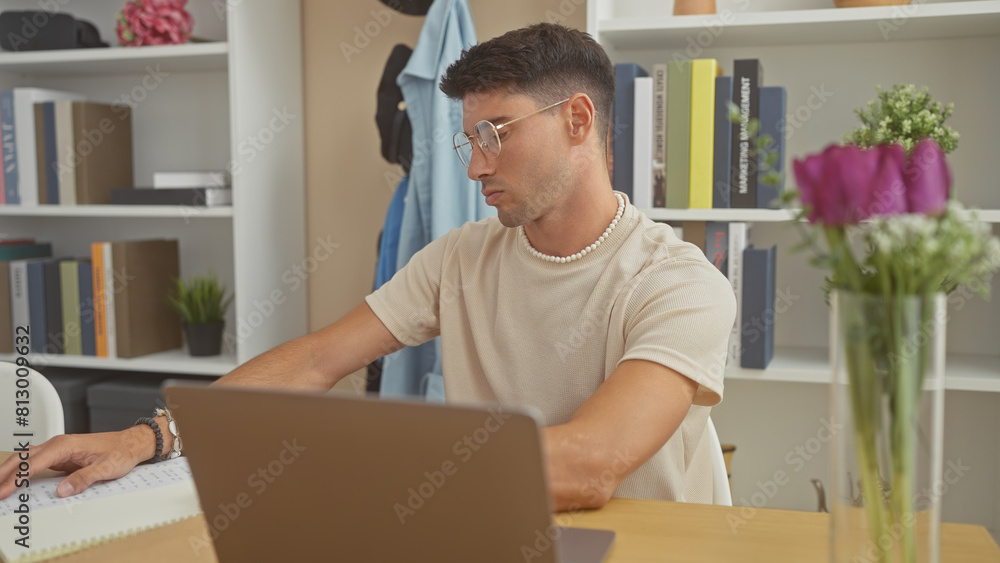 A handsome hispanic man works on a laptop at home, showing productivity and focus in a comfortable indoor setting. A handsome hispanic man works on a laptop at home, showing productivity and focus in a comfortable indoor setting.