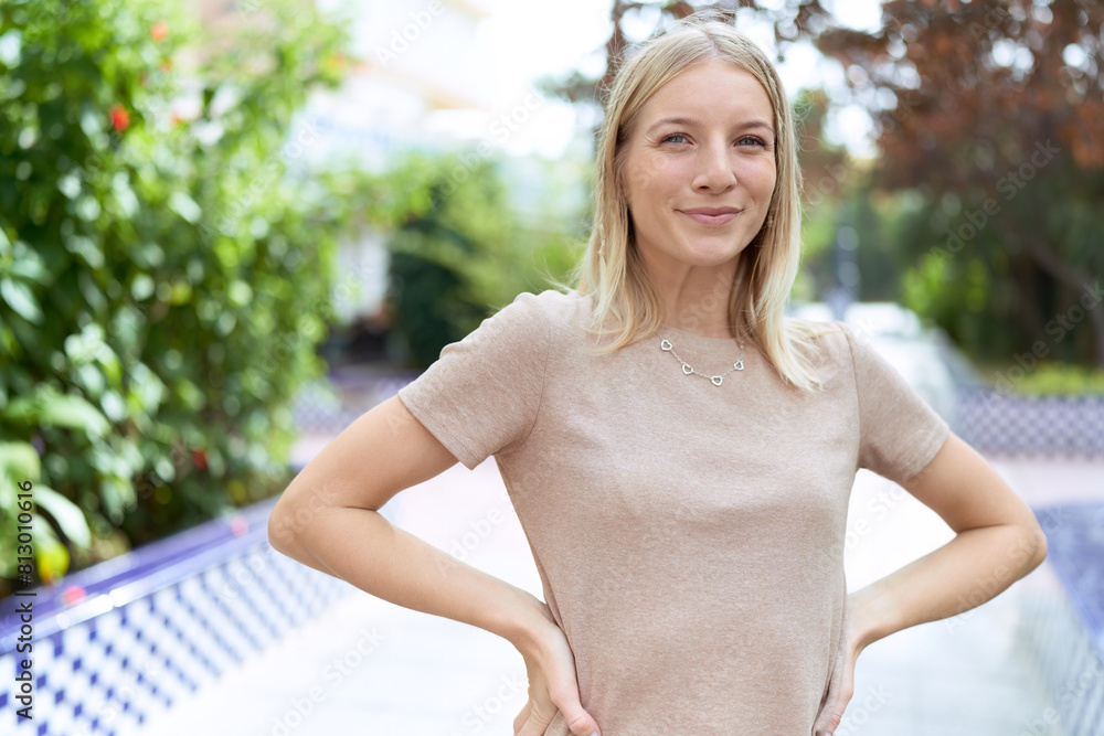 Naklejka premium Young blonde woman smiling confident standing at park