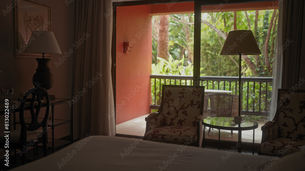 A tranquil hotel room with a comfortable bed, elegant furniture, inviting balcony, and a view of lush greenery. A tranquil hotel room with a comfortable bed, elegant furniture, inviting balcony, and a view of lush greenery.