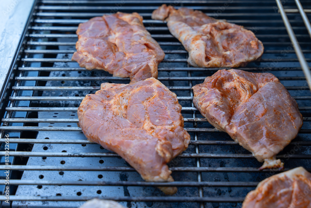 A grill with meat on it. The meat is brown and has a lot of seasoning on it A grill with meat on it. The meat is brown and has a lot of seasoning on it