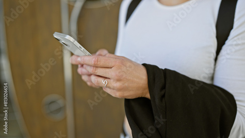 Close-up of a young woman's hands using a smartphone on a city street, embodying connection and urban lifestyle.