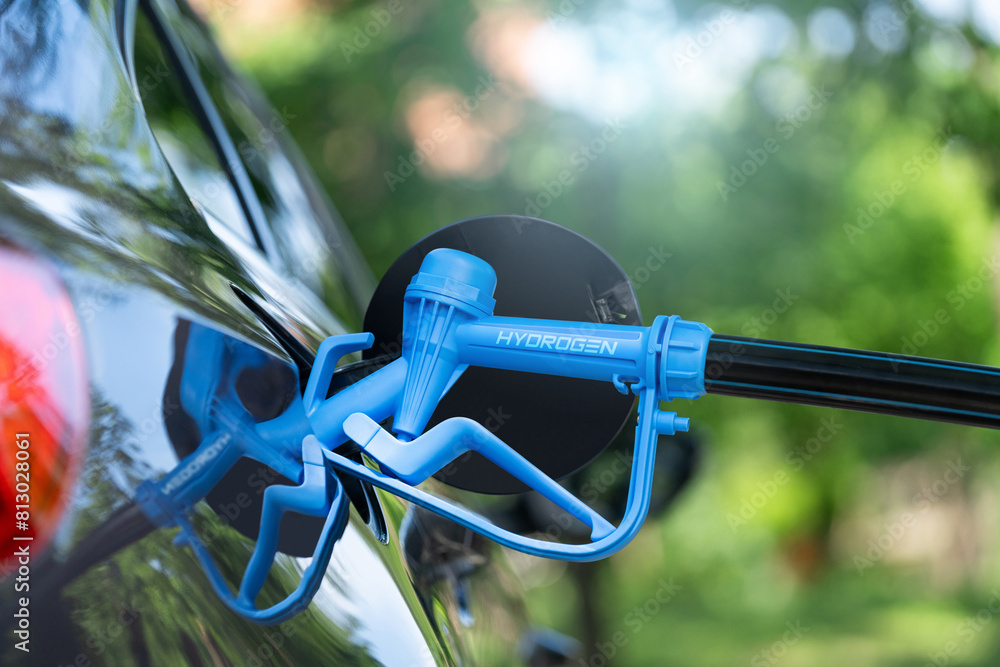 Close up of fuel cell car with connected hydrogen fueling nozzle Close up of fuel cell car with connected hydrogen fueling nozzle