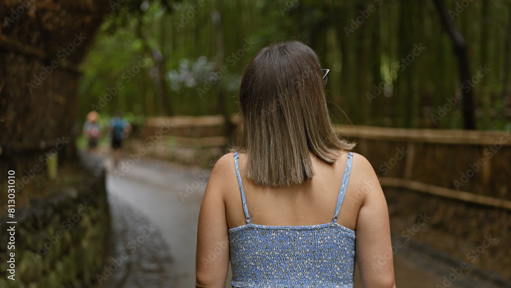 Beautiful young hispanic woman wearing glasses walking away at kyoto bamboo forest Beautiful young hispanic woman wearing glasses walking away at kyoto bamboo forest