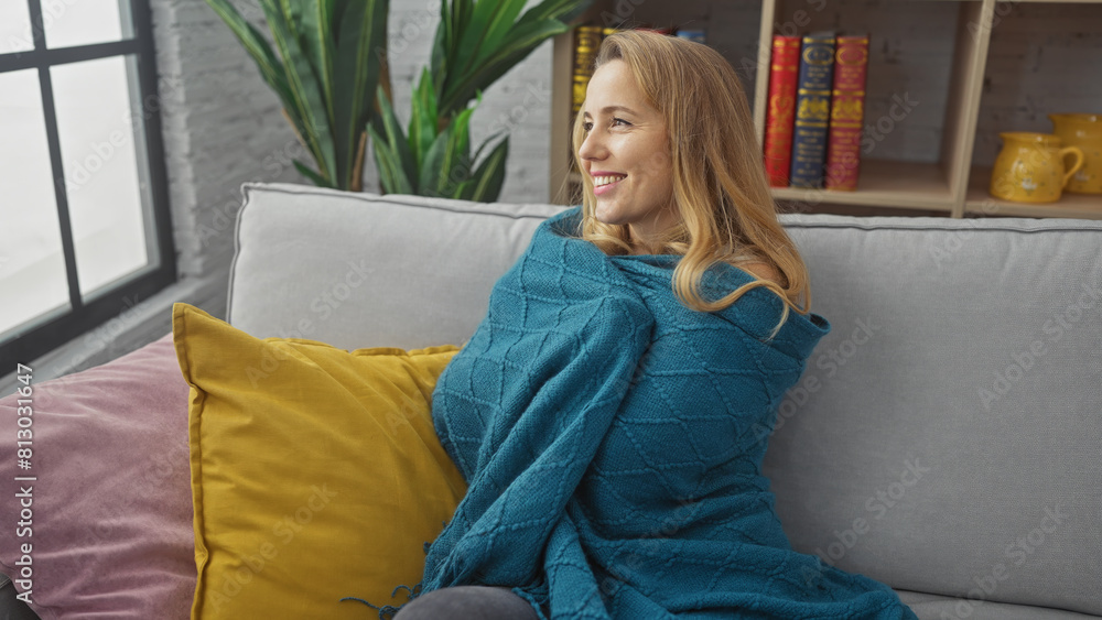 Blonde woman relaxing on couch with colorful pillows in a cozy living room. Blonde woman relaxing on couch with colorful pillows in a cozy living room.