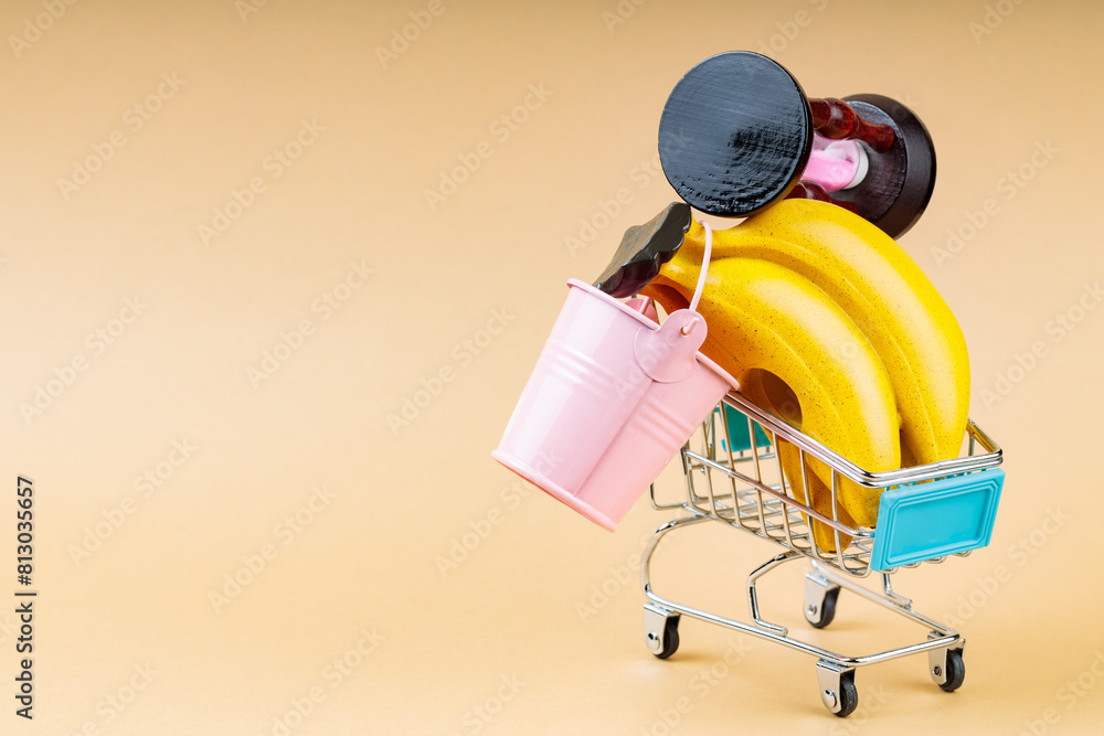 Overfilled Shopping Cart on Beige Background, Overconsumption Concept, Copy Space Overfilled Shopping Cart on Beige Background, Overconsumption Concept, Copy Space