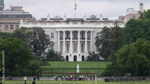 Timelapse of the White House in Washington DC with people looking at the house from the street in front