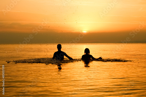 A happy couple in the sea on nature travel silhouette