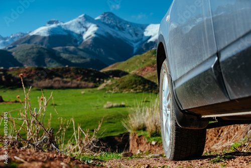 Car in picturesque mountain valley, travel concept, focus on wheel