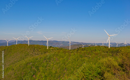 fields of wind turbines on the French hills in the herault on a blue sky background.