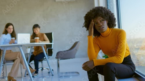 Discriminating co-workers. 4k video footage of a young businesswoman looking stressed out during a team meeting in a modern office. Worried young businesswoman