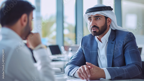 Middle Eastern businessmen in traditional attire having interview for company important position at a modern office. Modern business world and big money concept image. photo