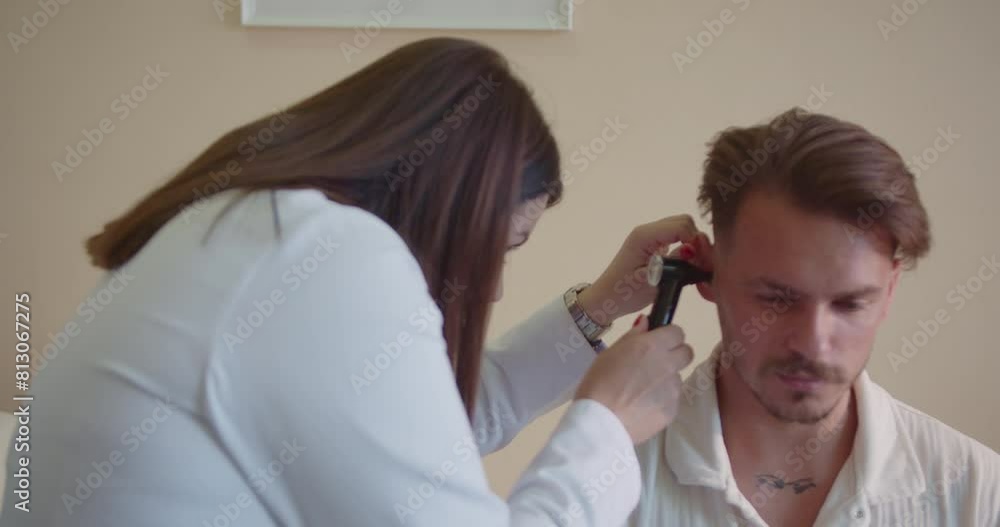 Female doctor checking young patient ears at the hospital. Female doctor checking young patient ears at the hospital.
