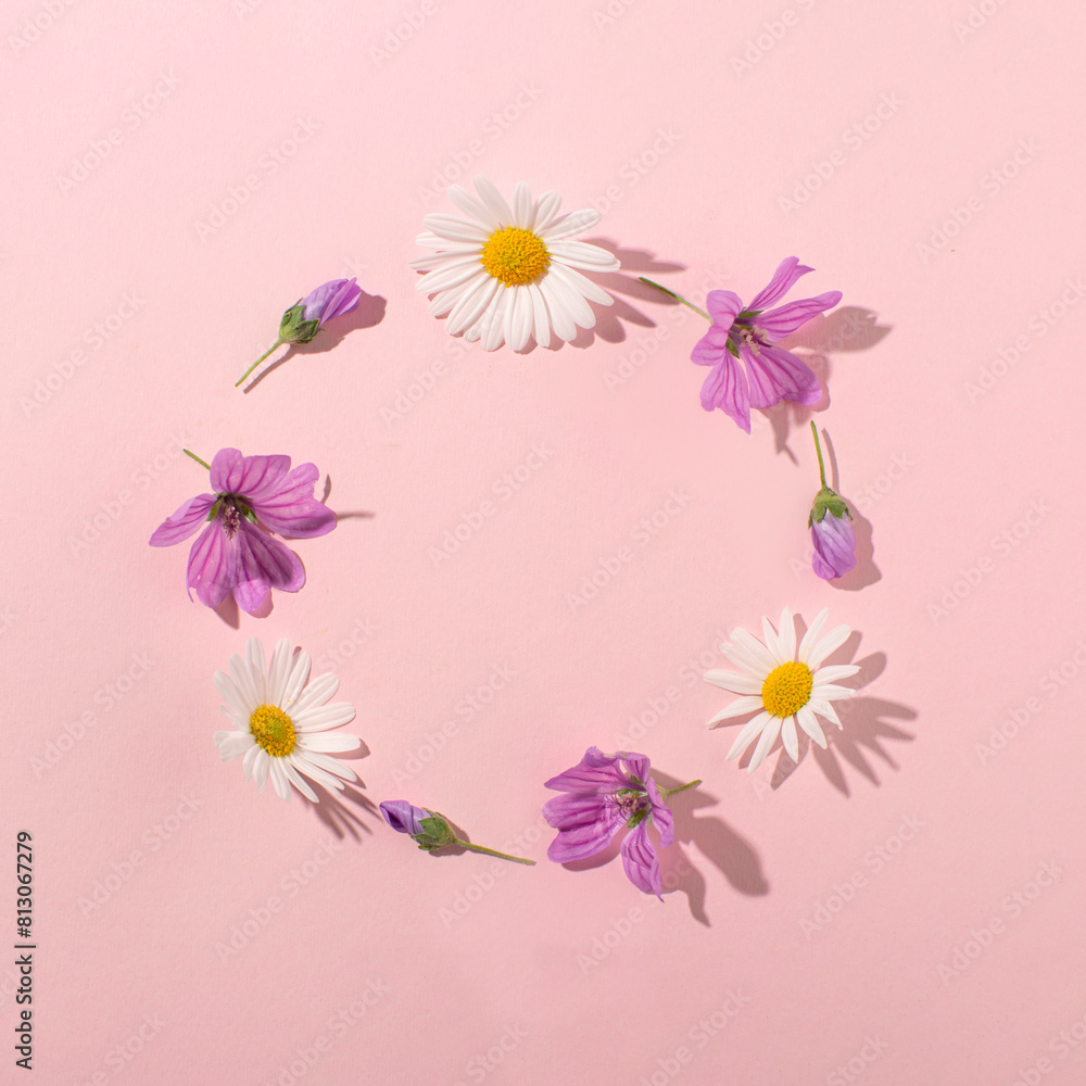 Fototapeta premium Wild spring flowers, simple circle wreath. Minimal, romantic floral flat lay composition, creative copy space, greeting card.