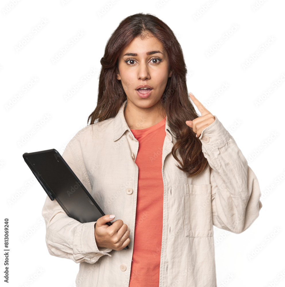 Middle Eastern woman with graphic tablet pointing upside with opened mouth. Middle Eastern woman with graphic tablet pointing upside with opened mouth.