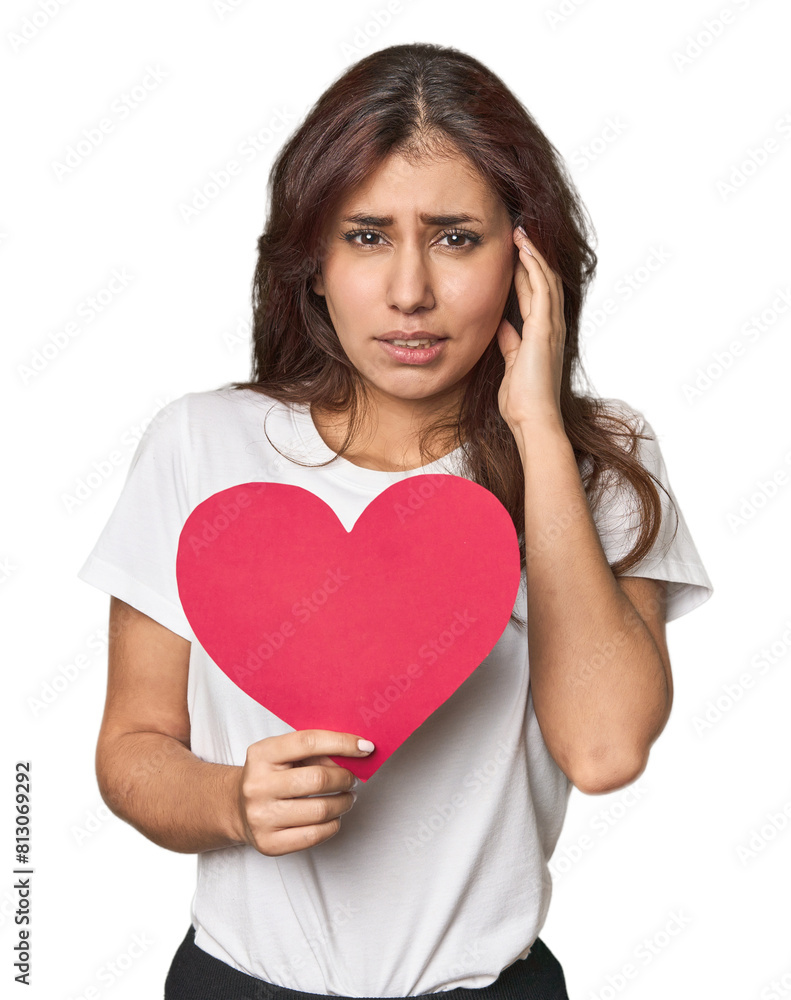 Middle Eastern woman holding paper heart covering ears with hands. Middle Eastern woman holding paper heart covering ears with hands.