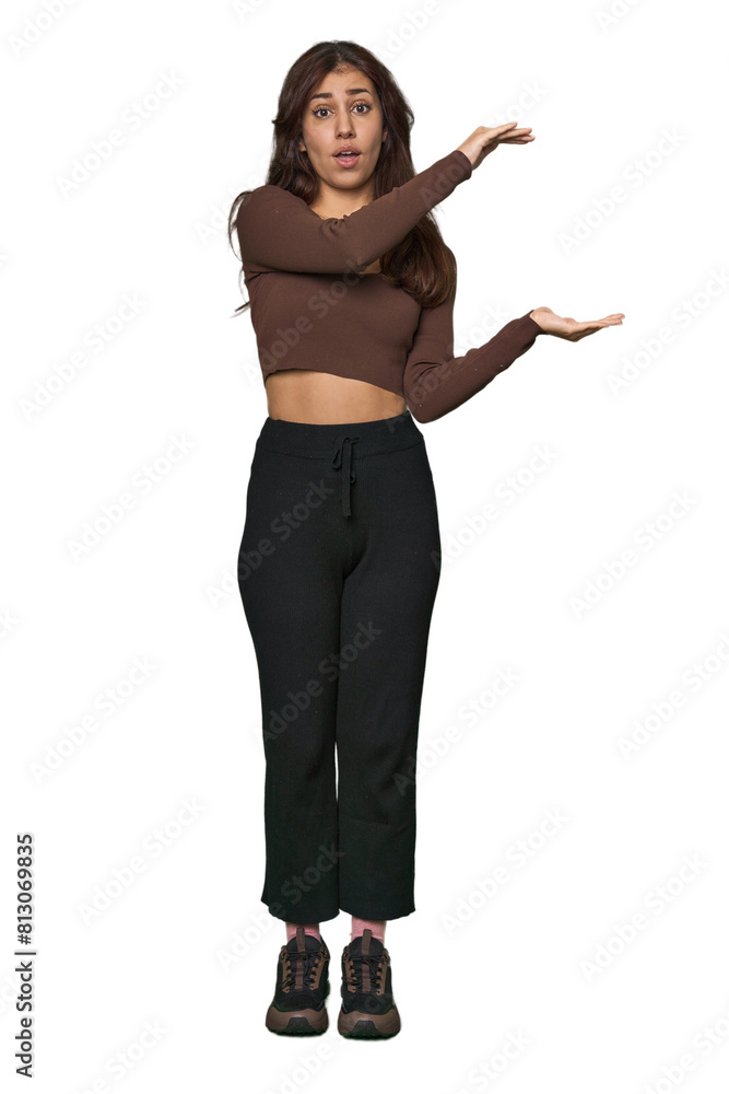 Middle Eastern woman, full body studio shocked and amazed holding a copy space between hands. Middle Eastern woman, full body studio shocked and amazed holding a copy space between hands.