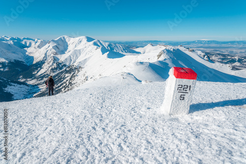 Fototapeta Naklejka Na Ścianę i Meble -  View from the trail towards Kasprowy Wierch on a winter day. The Polish-Slovak border marker is in the foreground.