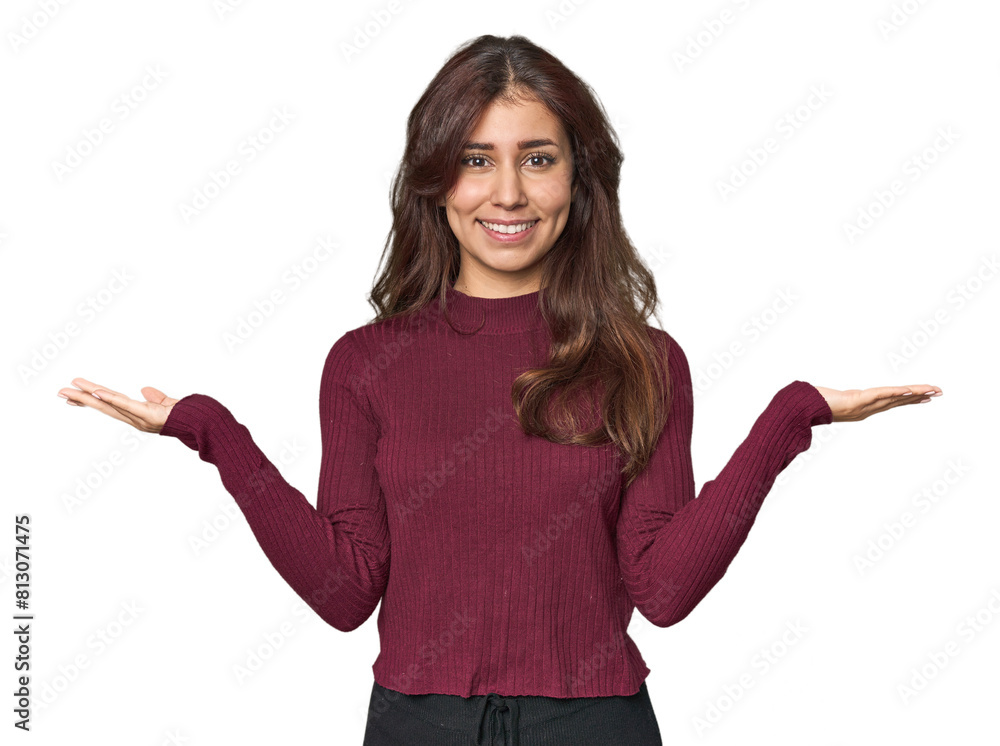 Middle Eastern woman in studio makes scale with arms, feels happy and confident. Middle Eastern woman in studio makes scale with arms, feels happy and confident.