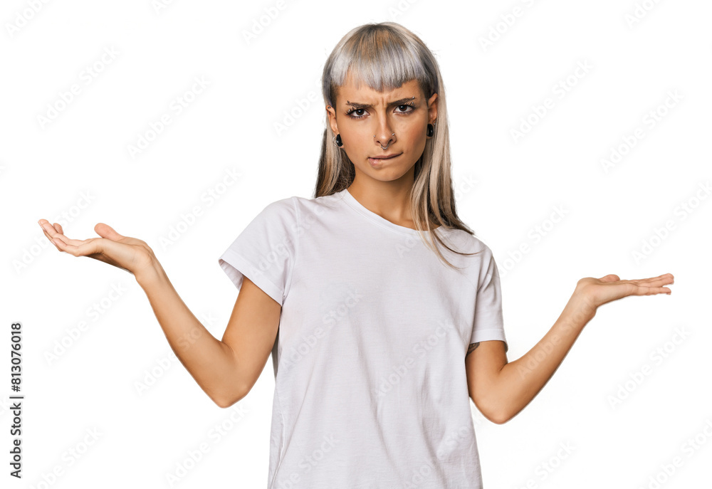 Young caucasian young woman in studio confused and doubtful shrugging shoulders to hold a copy space. Young caucasian young woman in studio confused and doubtful shrugging shoulders to hold a copy space.