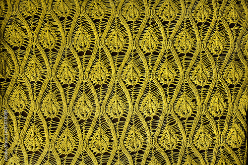 Texture yellow openwork close-up crochet. Yellow patterned background photo
