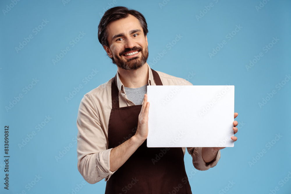 Portrait of barista showing whiteboard, posing in studio, isolated on blue. Copy space concept Portrait of barista showing whiteboard, posing in studio, isolated on blue. Copy space concept