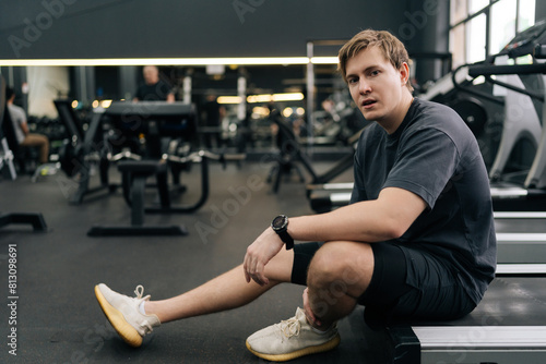 Fotografie Portrait of exhausted runner taking break at gym sit on treadmill