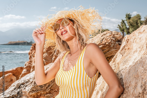 Gorgeous fashion model posing on a rocky beach. Fashion summer concept.