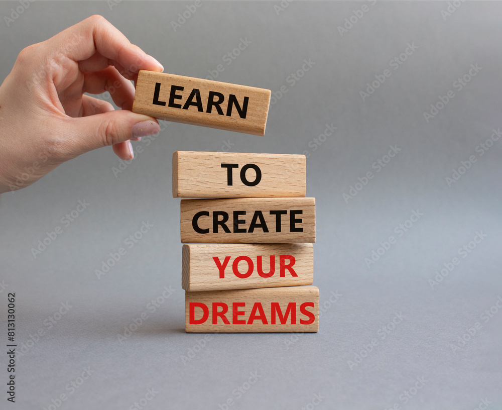 Dreams symbol. Concept words Learn to create your Dreams on wooden blocks. Beautiful grey background. Businessman hand. Business and Learn to create your Dreams concept. Copy space. Dreams symbol. Concept words Learn to create your Dreams on wooden blocks. Beautiful grey background. Businessman hand. Business and Learn to create your Dreams concept. Copy space.