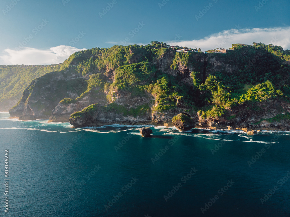 Landscape with rocky coastline and ocean with sunshine in Indonesia. Drone view.