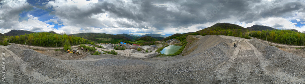 Carpathian Mountains of Ukraine, a quarry where granite sandstone is mined for the production of building materials, powerful trucks and conveyors load gravel - video from a drone