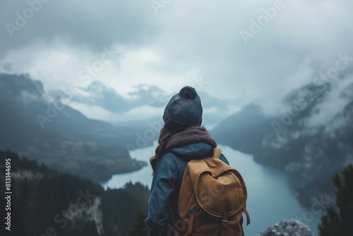 Hiker overlooking misty mountain lake © gearstd