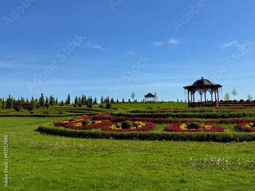 Beautiful landscaping in the park with lawns, ornamental shrubs, topiary balls. photo