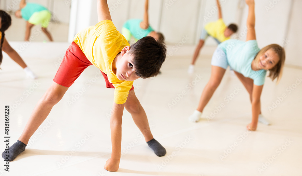 Obraz premium Youth boy dancing with his friends in dance studio during group training.
