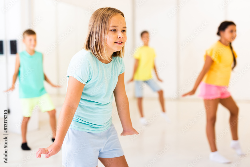 Fototapeta premium Girl and other kids dancing hip hop in dance studio
