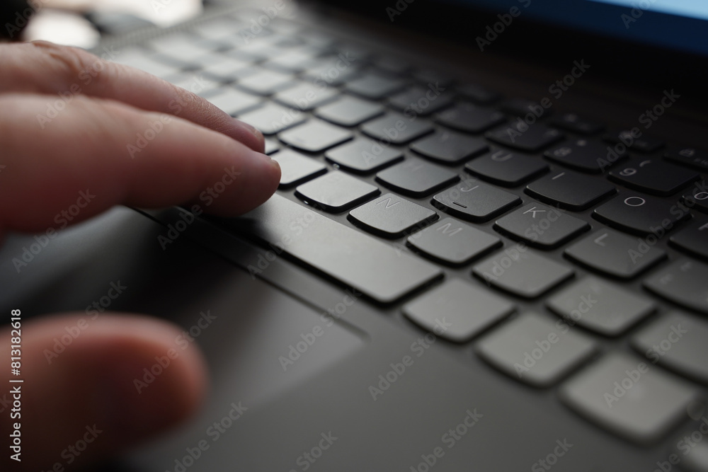 A close-up view of a person focusing on typing on a laptop keyboard A close-up view of a person focusing on typing on a laptop keyboard