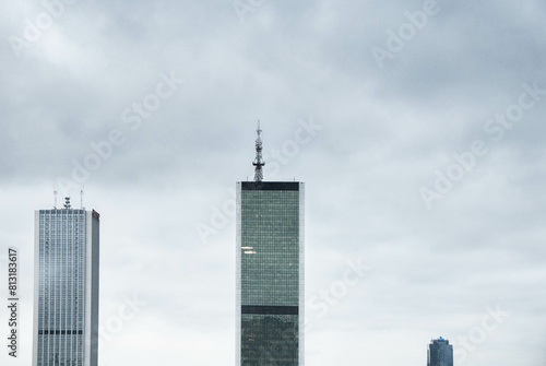 Composition of three modern glass buildings against the gray cloudy sky of Warsaw, Poland