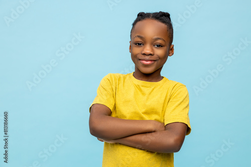 Smiling dark-skinned boy in yellow tshirt llooking contented