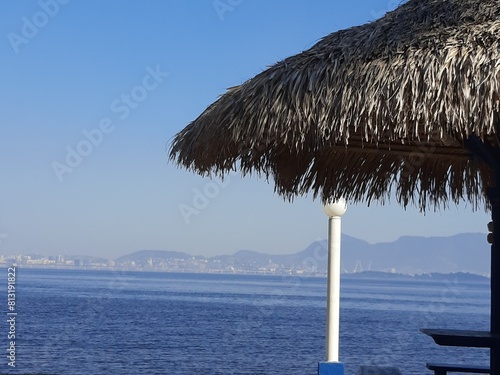 Férias, descanso em rede com sombra de palhoça e mar ao fundo -  Holidays, relaxing in a hammock with the shade of a hut and the sea in the background photo